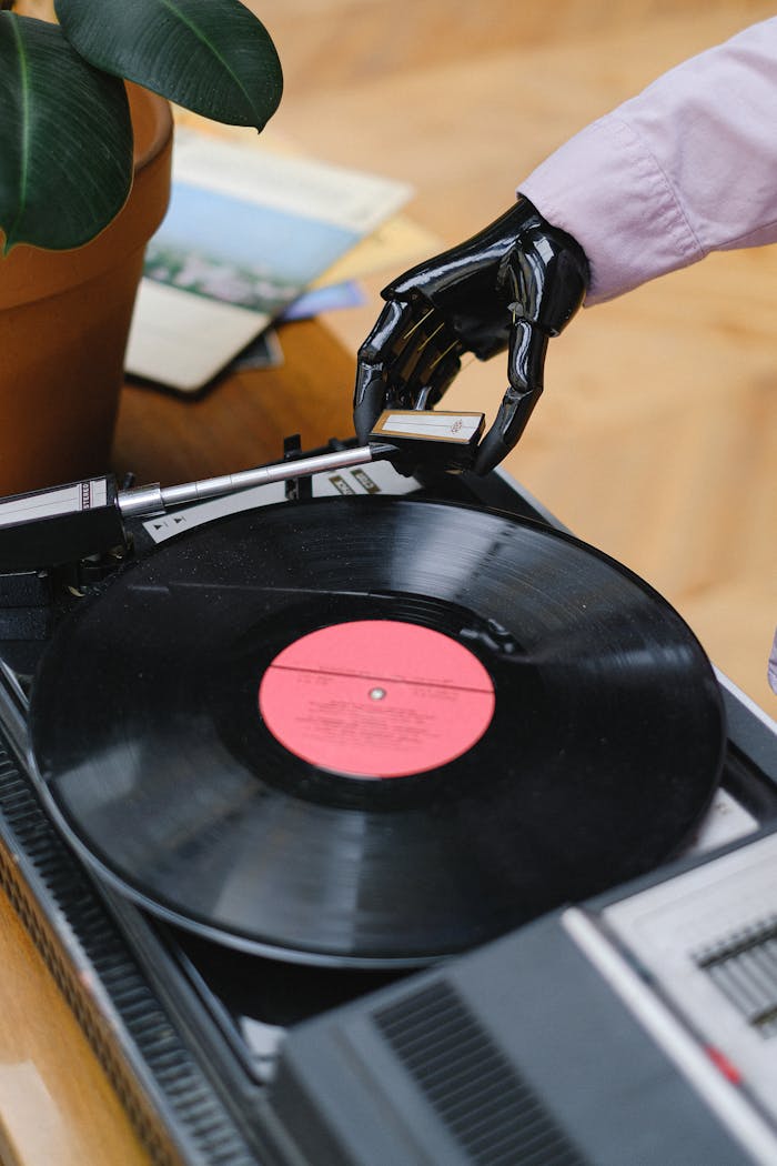 Close-up of a robotic hand interacting with a vintage turntable and vinyl record indoors.